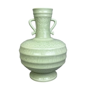 A double-handled ruyi-shaped vase with a carved longevity pattern and powder-green glaze.