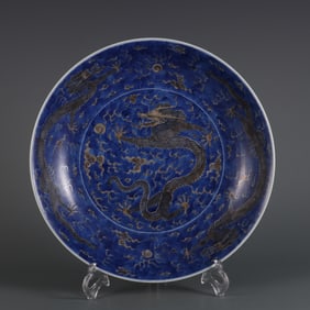 Blue and white porcelain plate with green dragon and cloud design