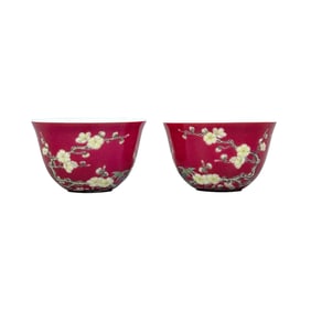 A pair of plum blossom and bamboo-themed cups with a rouge-red background.
