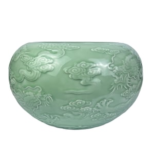 A celadon-glazed jar with relief design of a dragon teaching its son amidst waves and clouds.