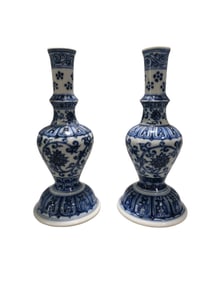 A pair of blue and white porcelain candlesticks with intertwined floral patterns