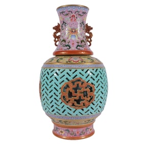 A revolving vase with a famille rose design featuring a phoenix tail and openwork design on a grassy