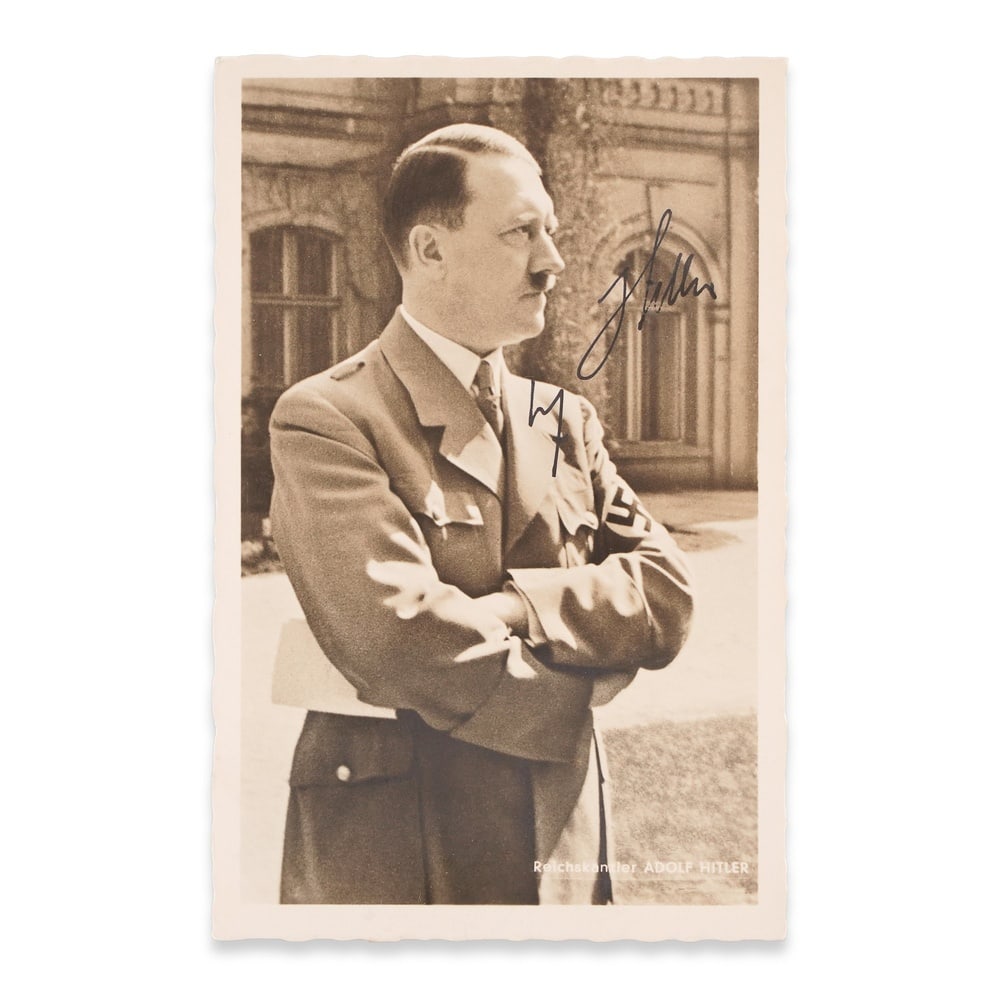ADOLF HITLER SIGNED POSTCARD: 5 1/2 x 3 1/2 in (14 x 9 cm) This signed historical postcard presents a period photographic portrait of Adolf Hitler, executed in a formal pose typical of official Third Reich imagery. The composition
