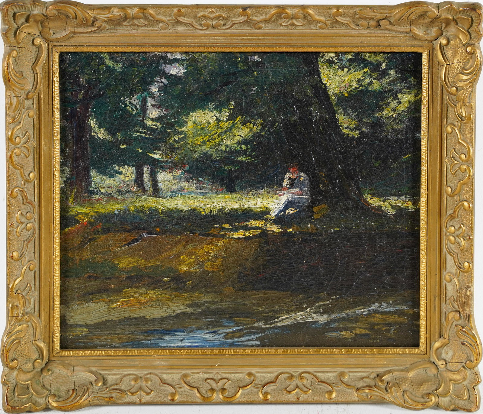 American Impressionist Painting Female Sketching Along a Rivers Edge: Antique American school oil depicting a woman who appears to be sketching while sitting in the shade of a tree along a river bank. A sun dappled forest clearing is very skillfully captured behind her.