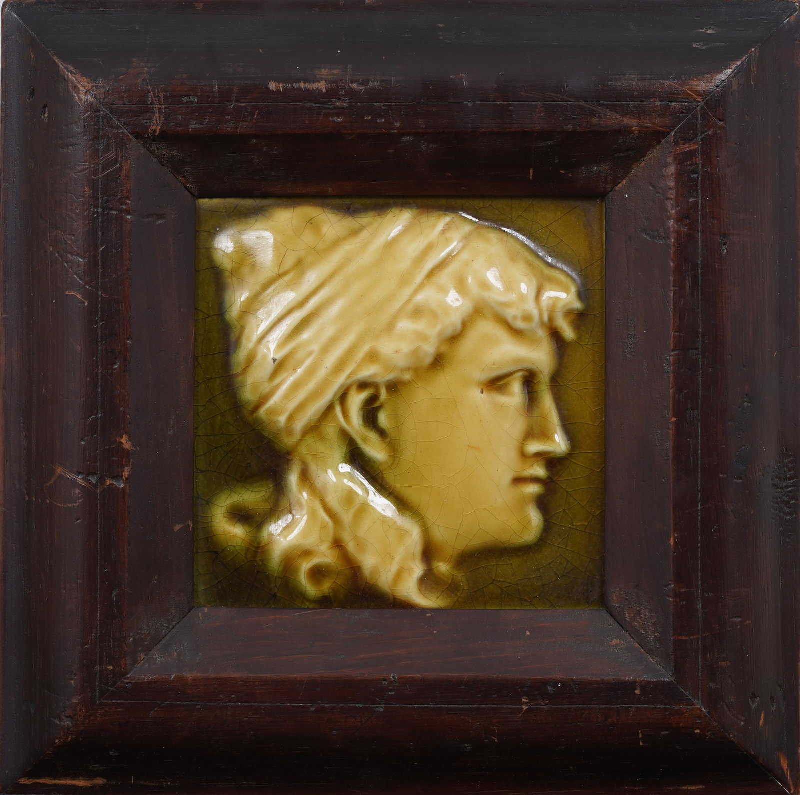 J & J G Low Figural Woman Profile Tile: Glazed porcelain portrait relief. Glazed porcelain. Measuring: 11.75 by 11.75 inches overall, and 6 by 6 painting alone. Please see all images for condition. Size is measured and written on the back o