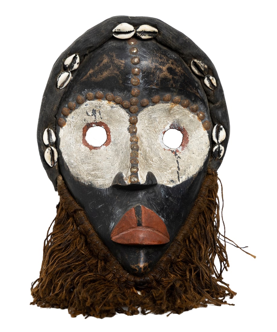 Tribal-Style Mask with Cowrie Shells and Fiber Beard: Decorated mask with cowrie shell adornments, raised dotted facial lines, painted white mask zone, and long fiber beard. Measuring: 14" x 9" wide x 4" deep. Size is measured and written on the back of