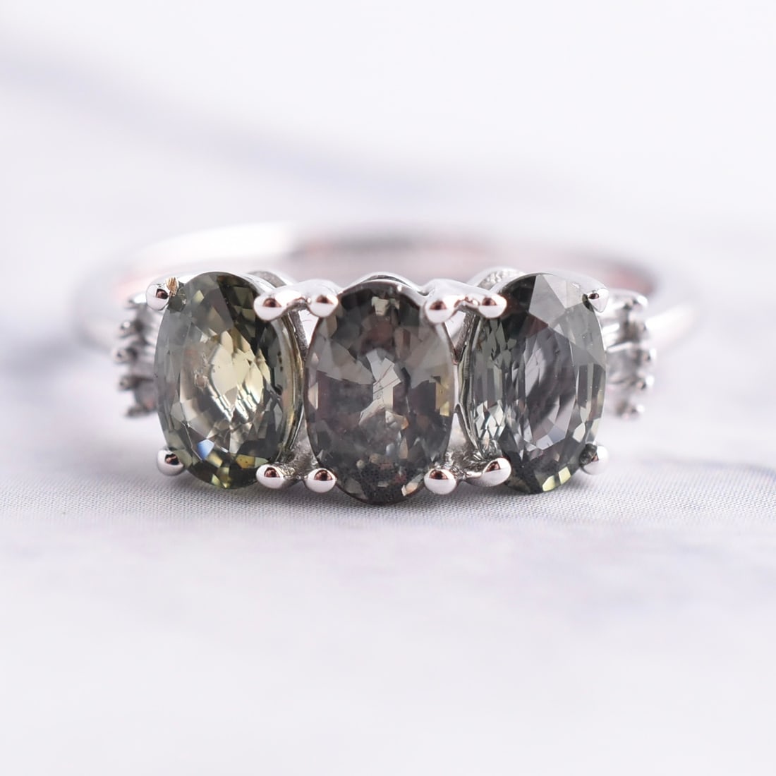 10k White Gold Tri Natural Bluish-Green Sapphire & Natural Diamond Ring: 10k White Gold | Approximate Weight: 1.8g | Sapphire & Diamond | Size 5 | Piece is marked "10k". Domestic flat rate shipping with Fedex is set to $45 plus insurance for this lot. Metals and stones