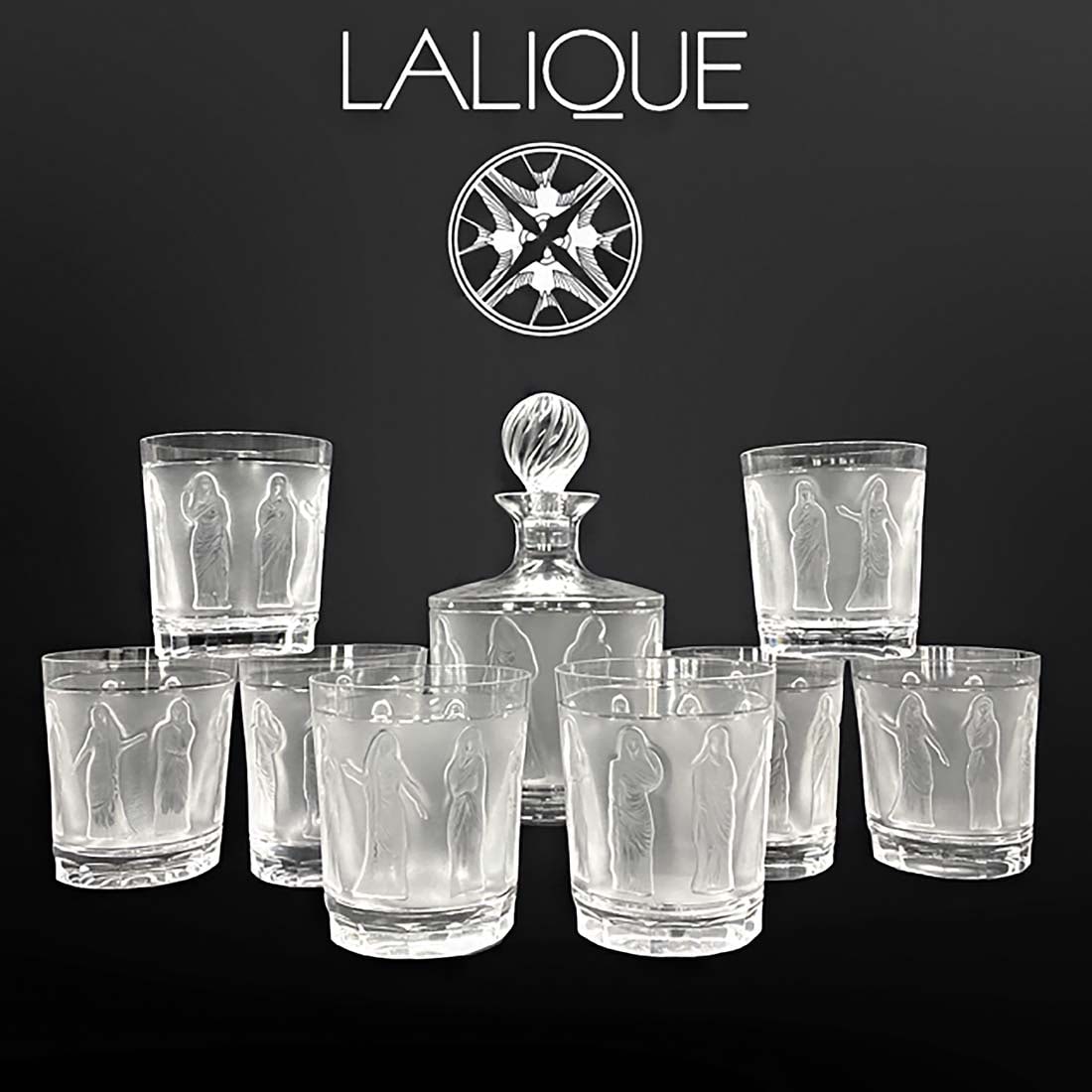 A Lalique Femme A L'Antique Crystal Liquor Service Set, Signed: A French Lalique Femme A L'Antique Crystal Liquor Service Set, Signed. Decanter: H 9.75" (24.5 cm) x D 5" (12.8 cm); tumblers: H 4 (10.00 cm) x D 3" (8.8 cm)