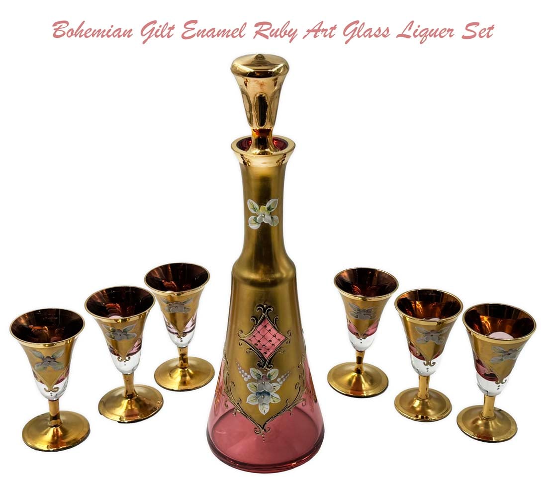A Vintage Bohemian Gilt Enameled Ruby Art Glass Liquor Set: A Vintage Bohemian Gilt Enameled Ruby Art Glass Liquor Set (7 pieces). Decanter: H 11.25" x D 3.5", Cups: H 3.75" x D 2"