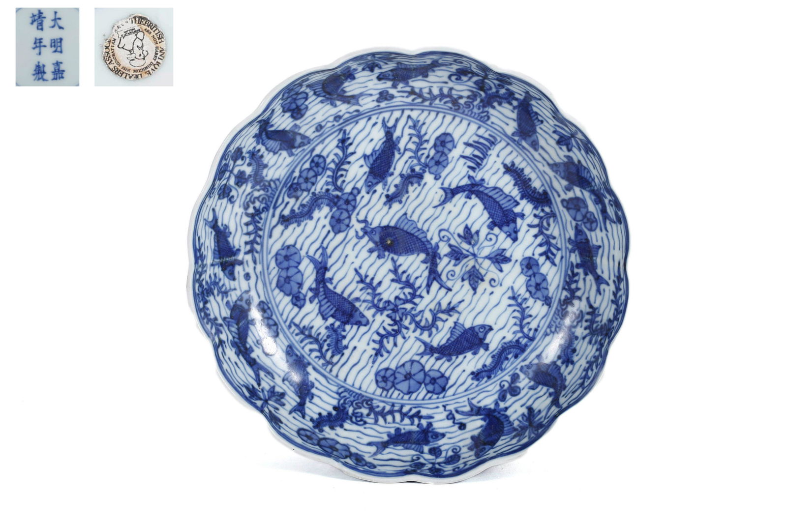 A Blue And White Carp And Algae Lobed Dish: A Blue And White Carp And Algae Lobed Dish 7 7/8 in. (20 cm.) diam. Jiajing Six-Character Mark. Provenance: Acquired from the British Antique Dealer Association. From the collection of William Cleverl
