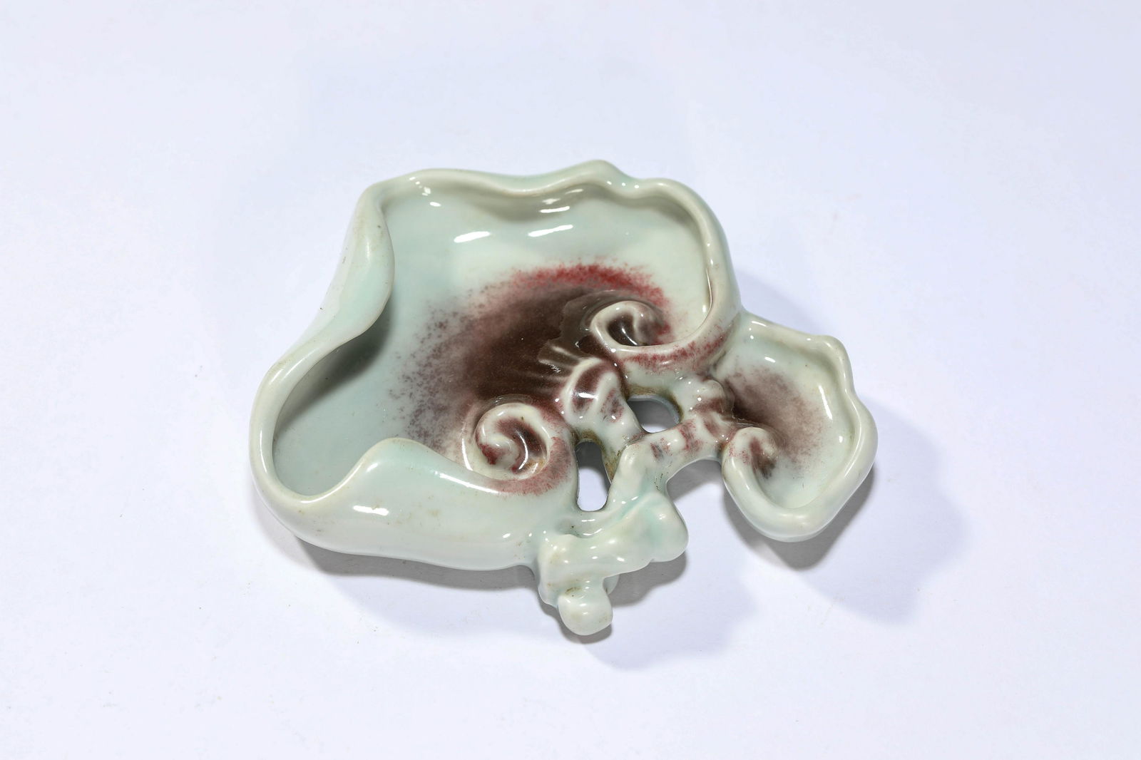 A Celadon And Copper Red Glaze Lingzhi-Form Brush Dip: A Celadon And Copper Red Glaze Lingzhi-Form Brush Dip The brush dip is well potted in shape of lingzhi fugues, the edge is reverted as lotus-petal form, copper red glaze to the middle area, all agains