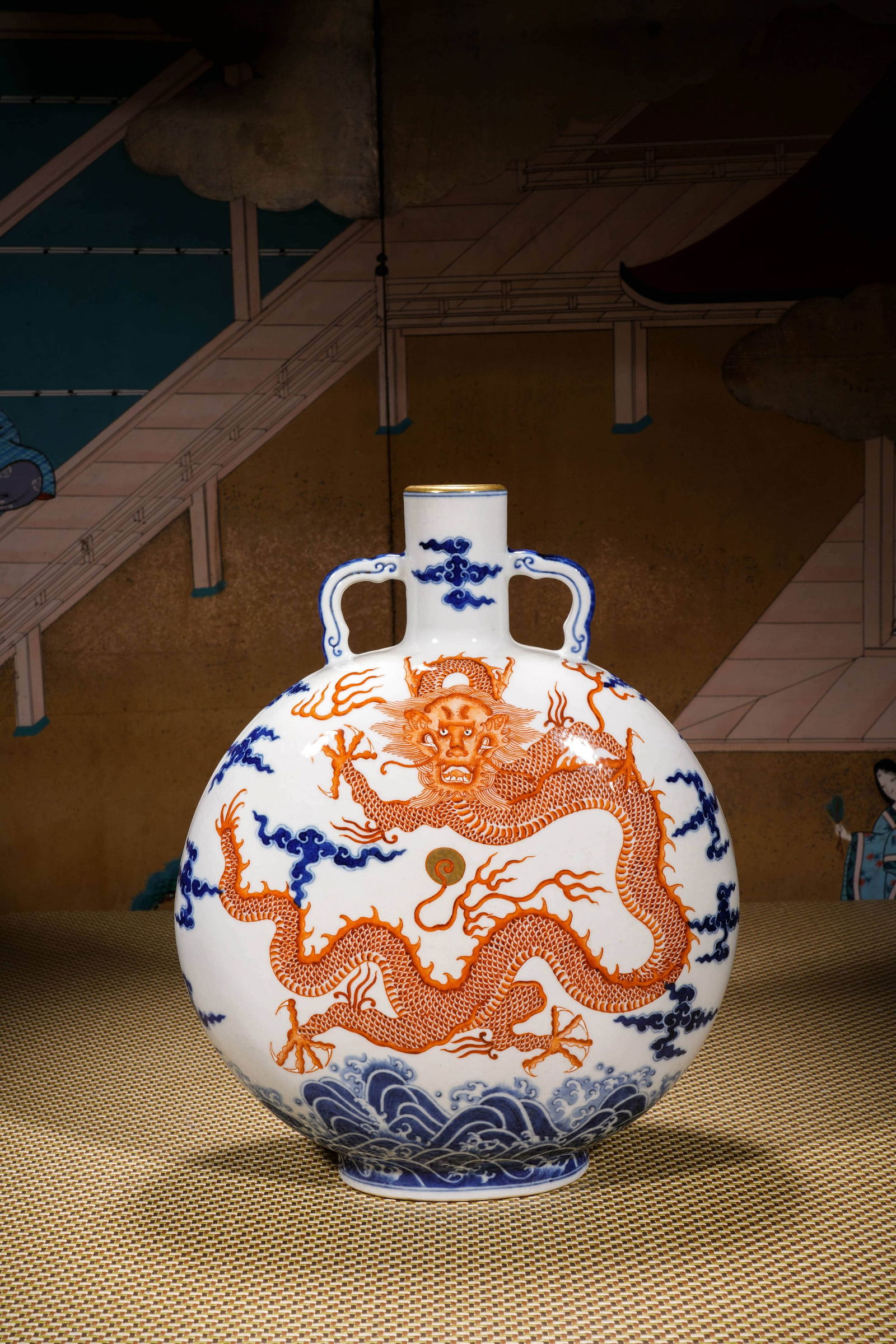 A BLUE AND WHITE IRON-RED DRAGON MOON FLASK: A BLUE AND WHITE IRON-RED DRAGON MOON FLASK Height: 32cm Each side of the vase is decorated in copper red of soft, shaded tones with a dragon leaping in pursuit of a flaming pearl amidst blue clouds a