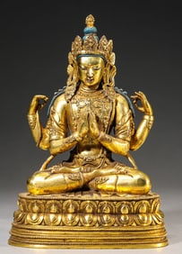 A GILT-BRONZE FIGURE OF SEATED FOUR-ARMED GUANYIN