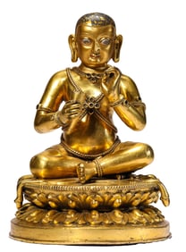A GILT-BRONZE FIGURE OF SEATED GURU