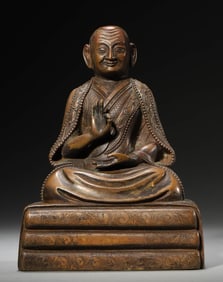 A BRONZE FIGURE OF SEATED GURU