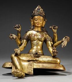 A GILT-BRONZE FIGURE OF SEATED SIX-ARMED VASUDHARA