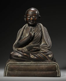 A GILT-BRONZE AND SILVER INLAID FIGURE OF SEATED GURU