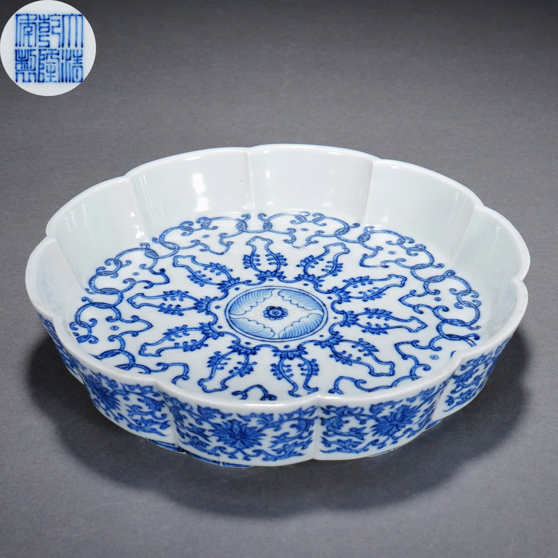 A QIANLONG BLUE AND WHITE 'SCROLLING LOTUS' DISH: A QIANLONG BLUE AND WHITE 'SCROLLING LOTUS' DISH Dimensions: Width: 18.5 cm (7 5/16 in.), Height: 4 cm (1 9/16 in.) All measurements are approximate. Any condition statement is given as a courtesy to