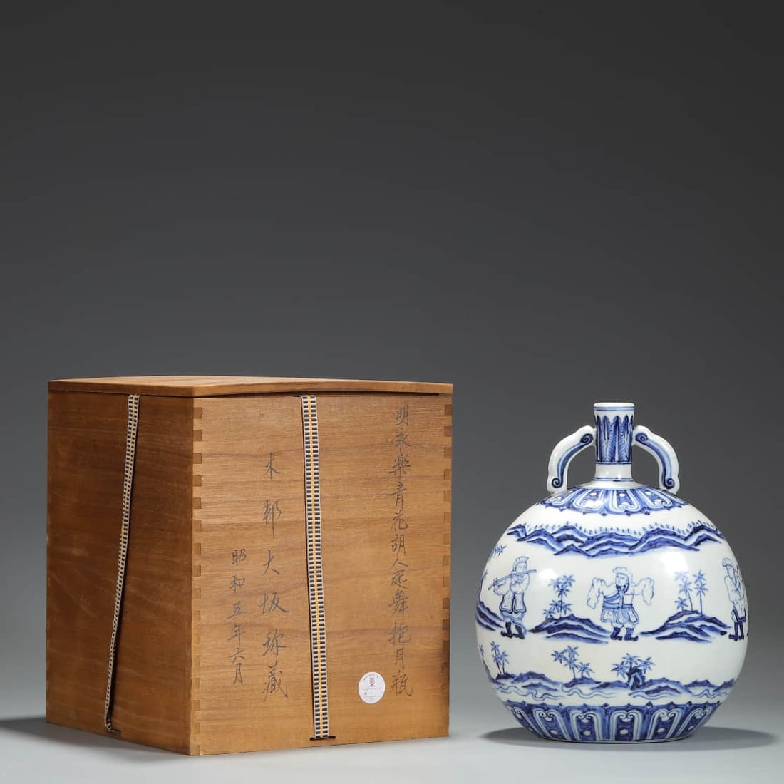 A BLUE AND WHITE 'DANCING HU PEOPLE' MOON FLASK.: A BLUE AND WHITE 'DANCING HU PEOPLE' MOON FLASK. Dimensions: Height: 27 cm (10.63 in.), Belly Diameter: 20.5 cm (8.07 in.), Diameter: 3 cm (1.18 in.). All measurements are approximate. Any condition s