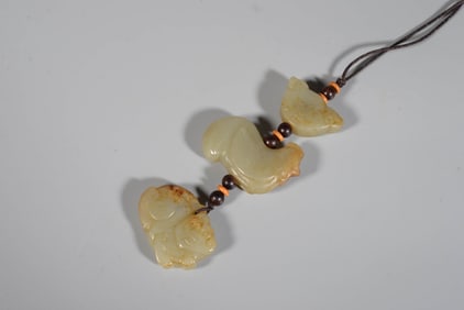A CELADON JADE 'SKIN-RETAINED TREASURES' BEAD STRAND