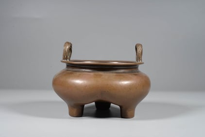 A BRONZE DOUBLE-HANDLE TRIPOD CENSER