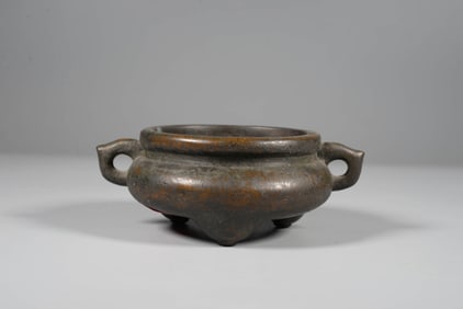 A BRONZE DOUBLE-HANDLE TRIPOD CENSER