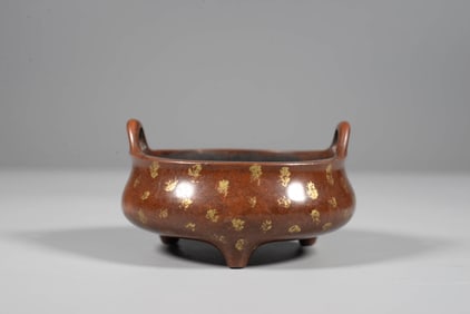 A BRONZE 'GOLD-SPLASHED' BRIDGE-HANDLE TRIPOD CENSER