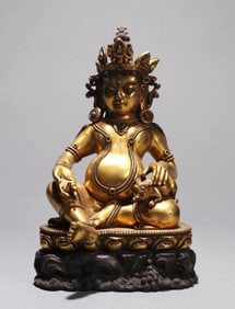 A GILT-BRONZE FIGURE OF JAMBHALA