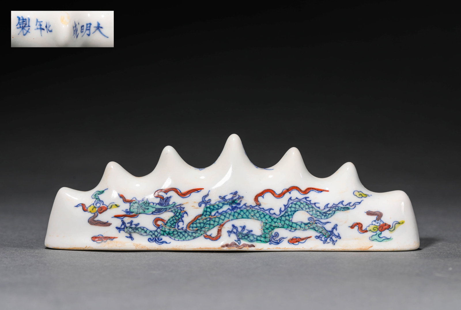 A DOUCAI 'DRAGON AND PHOENIX' BRUSH REST: A DOUCAI 'DRAGON AND PHOENIX' BRUSH REST Dimensions: Width: 15 cm (5.9 in.), Height: 4.7 cm (1.9 in.). All measurements are approximate. Any condition statement is given as a courtesy to a client, is 