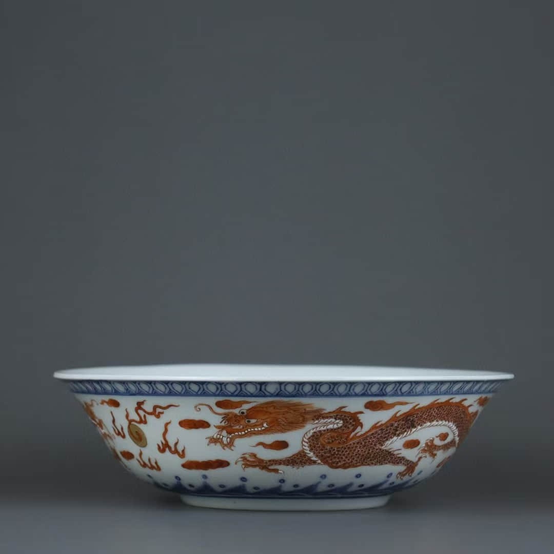 A BLUE AND WHITE WITH IRON-RED 'TWO DRAGONS CHASING PEARL' BOWL: A BLUE AND WHITE WITH IRON-RED 'TWO DRAGONS CHASING PEARL' BOWL Dimensions: Height: 6 cm (2.4 in.), Diameter: 20.7 cm (8.1 in.). All measurements are approximate. Any condition statement is given as a