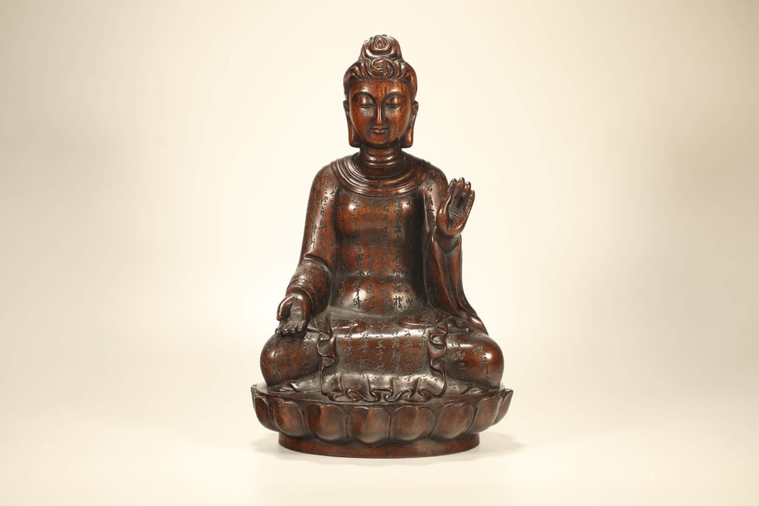 A CARVED EAGLEWOOD 'SEATED SAKYAMUNI WITH SUTRA' STATUE (1 of 7)