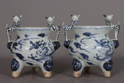 A PAIR OF BLUE AND WHITE 'DRAGON' TRIPOD CENSERS