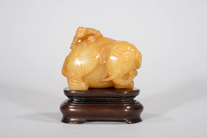 A YELLOW JADE 'ELEPHANT' FIGURE (WITH ROSEWOOD STAND)