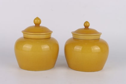 A PAIR OF YELLOW-GLAZED COVERED JARS