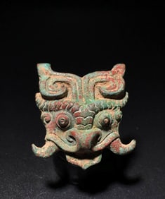 A BRONZE 'BEAST MASK' BELT PLAQUE WITH RED AND GREEN PATINA