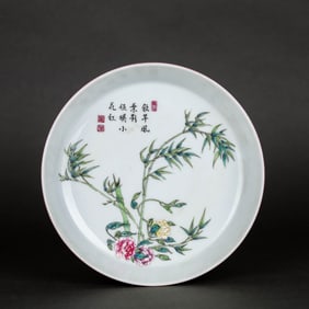 AN EXTERIOR RUBY RED-GLAZED, INTERIOR FAMILLE ROSE 'BAMBOO, FLOWERS AND POETRY' DISH