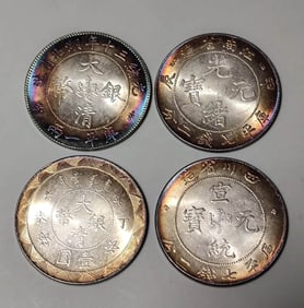 FOUR MULTICOLORED SILVER COINS