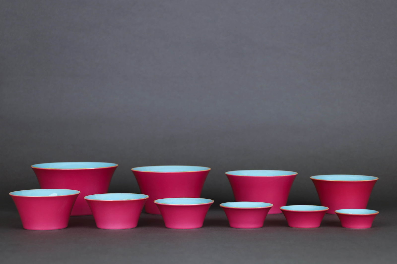 A SET OF TURQUOISE-GREEN GLAZED INTERIOR AND RUBY-RED GLAZED EXTERIOR HORSESHOE-SHAPED CUPS: A SET OF TURQUOISE-GREEN GLAZED INTERIOR AND RUBY-RED GLAZED EXTERIOR HORSESHOE-SHAPED CUPS Dimensions: Height: 6.8 cm (2.68 in.), Diameter: 11.8 cm (4.65 in.). All measurements are approximate.