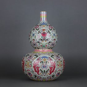 A CELADON-GLAZED FAMILLE ROSE 'DRAGON, BAT, SHOU AND FLOWERS' GOURD-SHAPED VASE