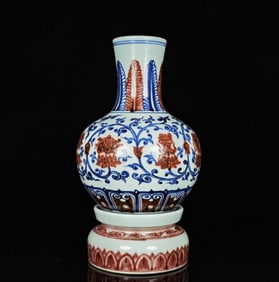 A BLUE AND WHITE WITH UNDERGLAZED RED 'INTERLOCKING FLOWERS HOLDING EIGHT TREASURES' REVOLVING VASE