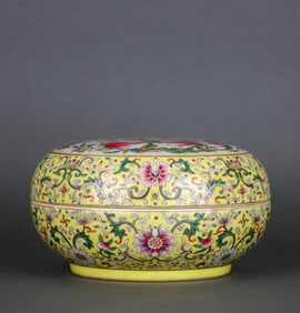 A YELLOW-GROUND FAMILLE ROSE 'INTERLOCKING FLOWERS AND NINE PEACHES' COVERED BOX