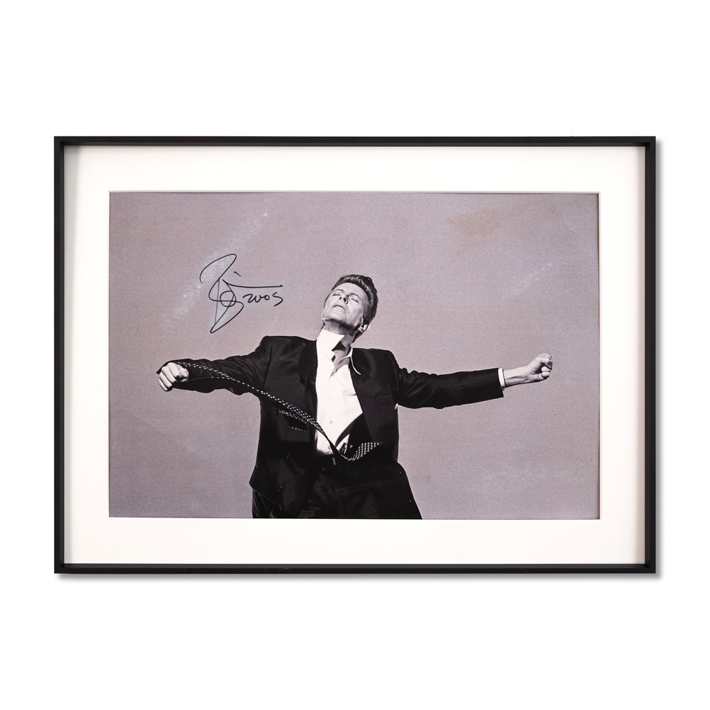 DAVID BOWIE SIGNED POSTER: Sight Size: 19 3/4 x 13 1/8 in (50.3 x 33.4 cm) Frame Size: 24 1/8 x 17 1/2 in (61.2 x 44.3 cm) This striking poster captures an iconic moment of rock legend David Bowie mid-performance, arms outstret