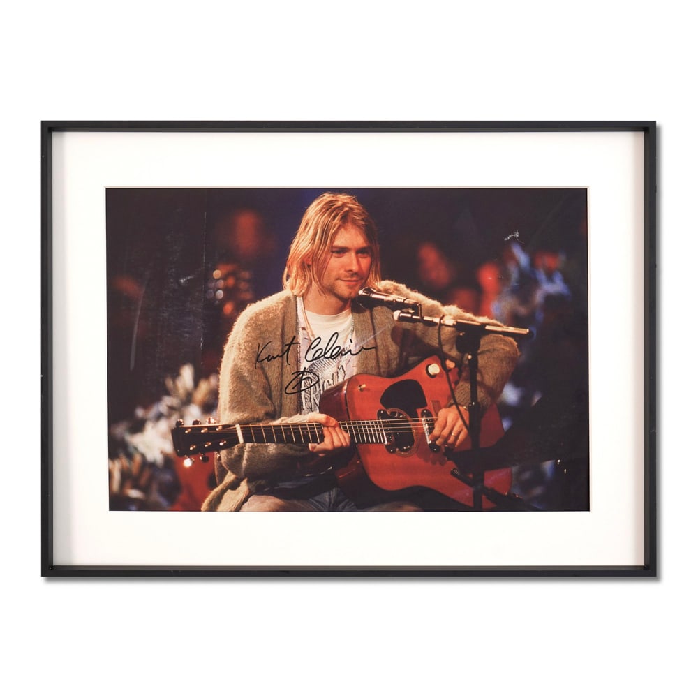 KURT COBAIN SIGNED POSTER: Sight Size: 16 1/8 x 10 7/8 in (41.1 x 27.5 cm) Frame Size: 20 1/2 x 15 1/4 in (52.2 x 38.8 cm) This evocative photograph captures Kurt Cobain during Nirvana's iconic 1993 MTV Unplugged performance, a
