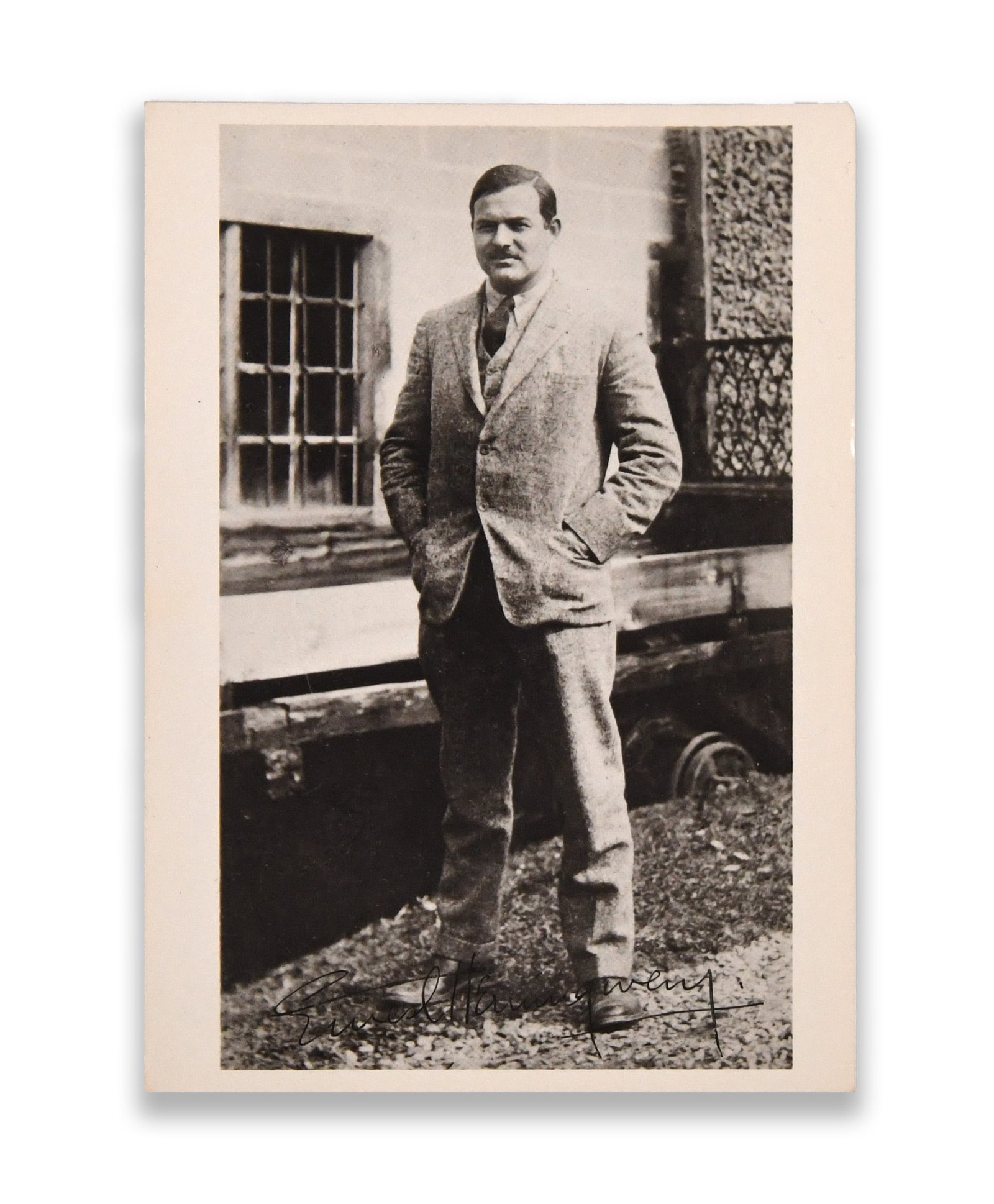 ERNEST HEMINGWAY - SIGNED PHOTOGRAPHIC POSTCARD (C. 1920S-1930S): ERNEST HEMINGWAY - SIGNED PHOTOGRAPHIC POSTCARD (C. 1920S-1930S) Provenance and Authenticity: The photograph bears a fluid ink signature along the lower margin reading "Ernest Hemingway," executed in 