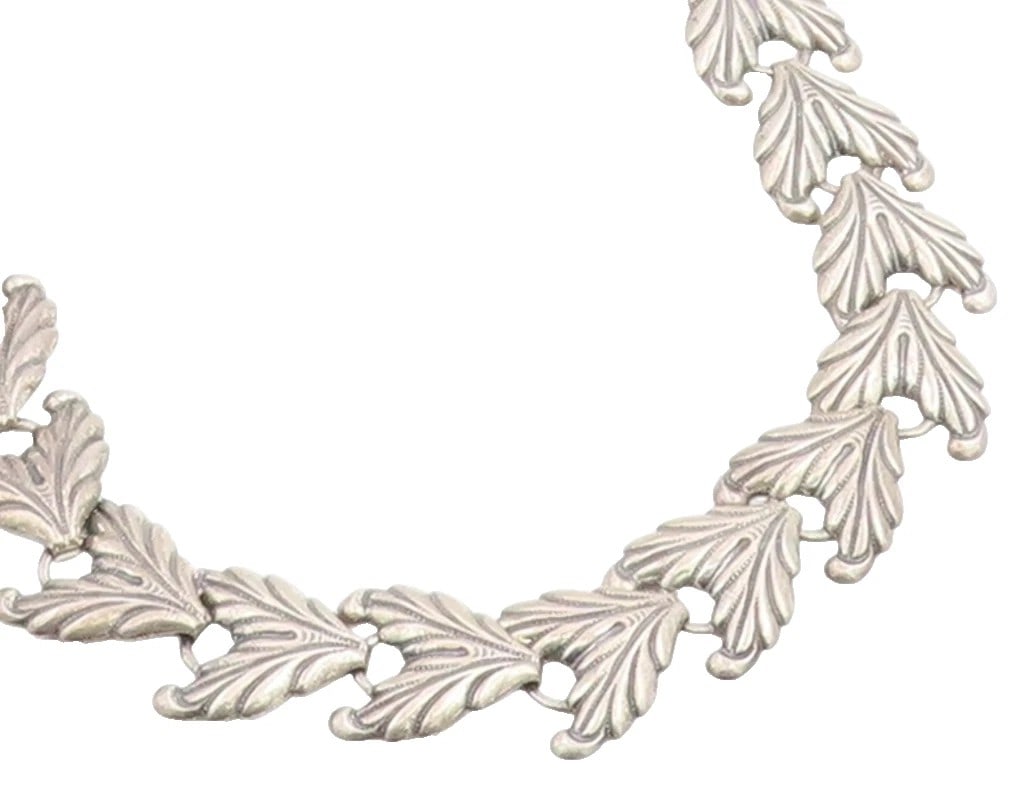 SILVER LEAF-LINK NECKLACE: SILVER LEAF-LINK NECKLACE Description: A silver necklace composed of repeating leaf-form links. The images document the necklace layout and close detail of the textured leaf pattern.