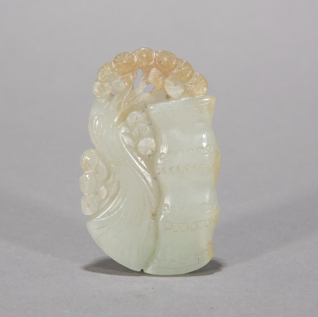 A PALE CELADON JADE 'PINE, BAMBOO AND PRUNUS' HANDLE ORNAMENT (1 of 3)