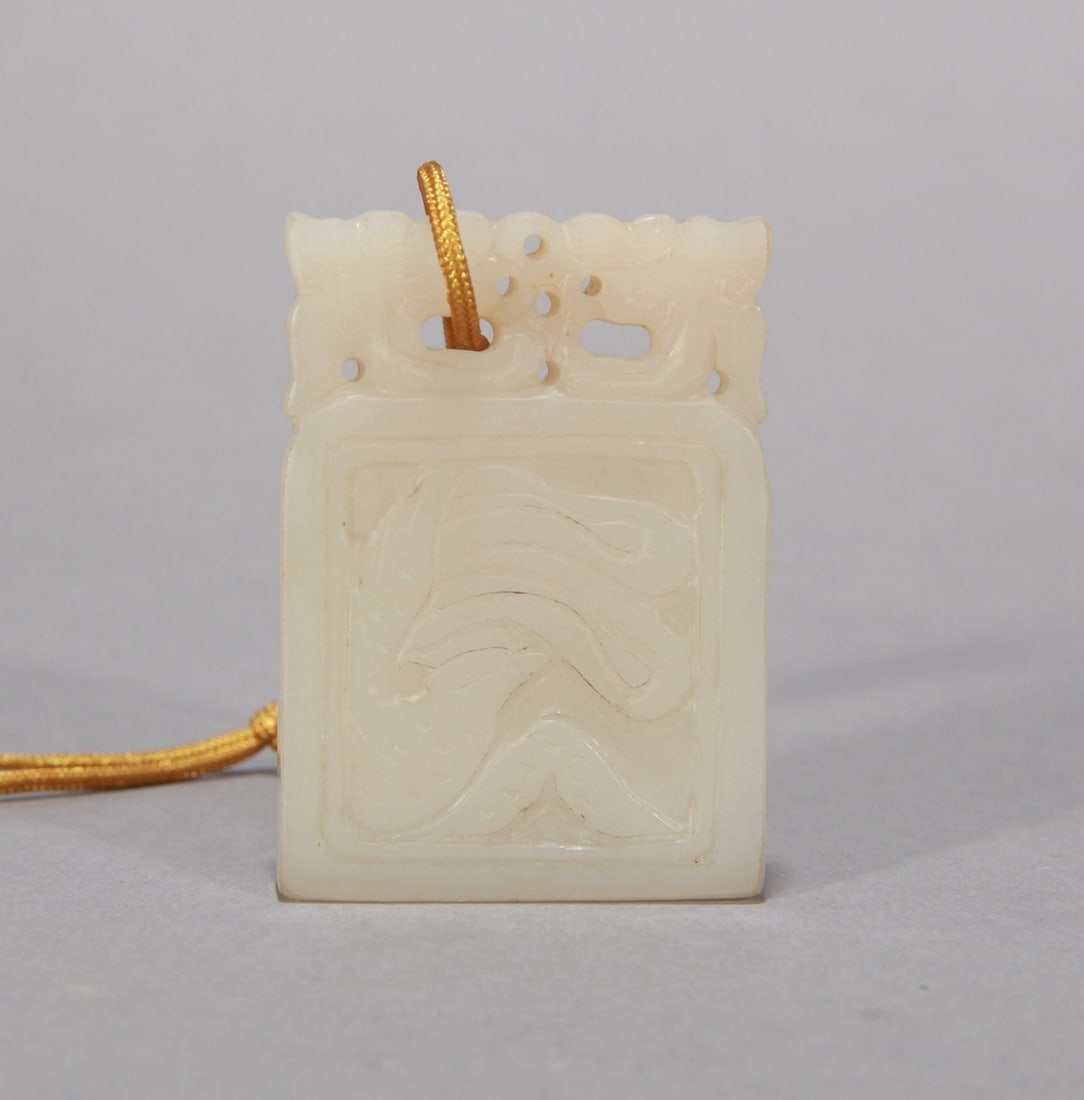 A WHITE JADE 'PHOENIX' PENDANT: A WHITE JADE 'PHOENIX' PENDANT Dimensions: Dimensions: Width: 4.8 cm (1.89 in.) x Height: 3.4 cm (1.34 in.). All measurements are approximate.