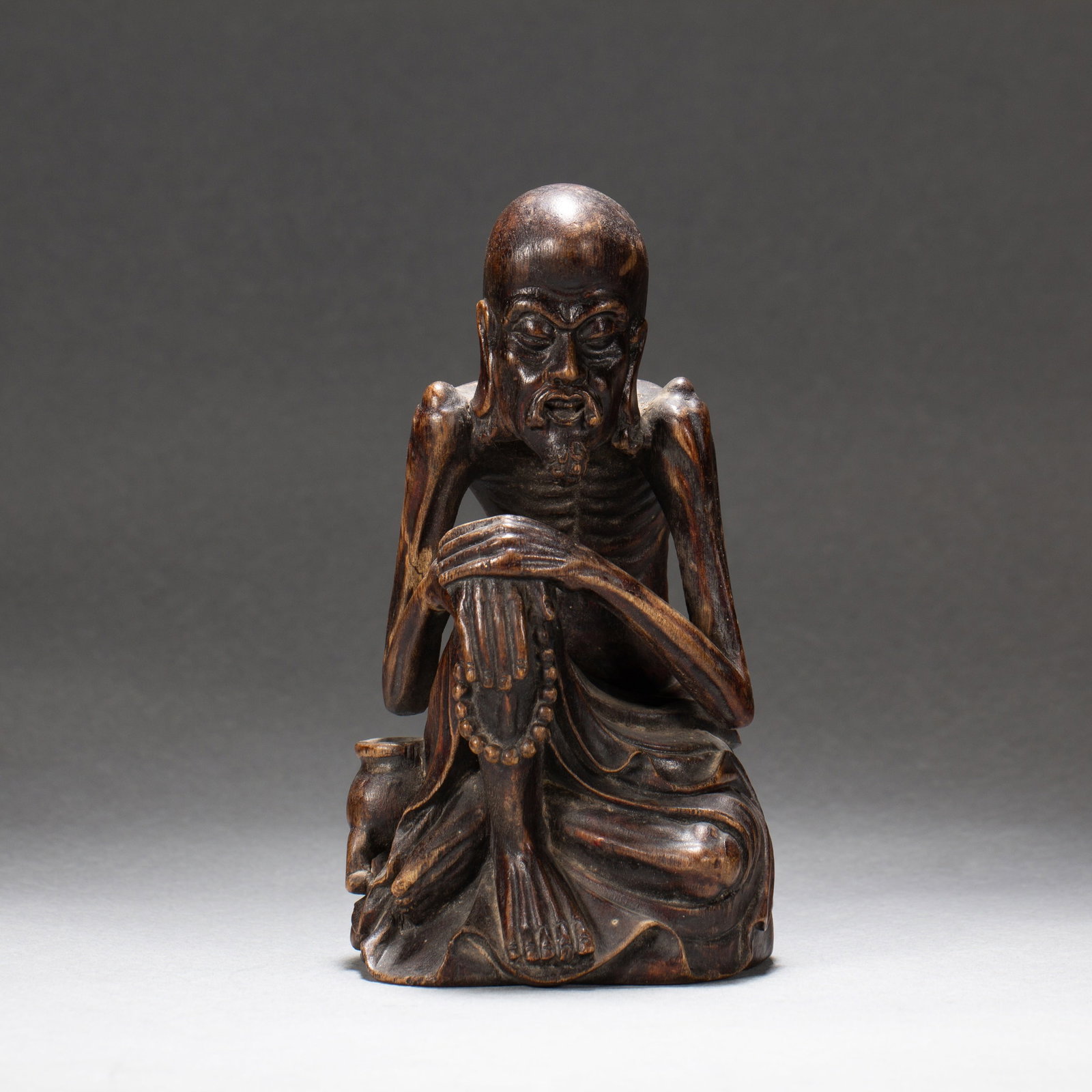 AN ALGUM WOOD 'FIGURES' ORNAMENT: AN ALGUM WOOD 'FIGURES' ORNAMENT Dimensions: Dimensions: Length: 8.5 cm (3.35 in.), Width: 8.5 cm (3.35 in.), Height: 15.5 cm (6.10 in.). Weight: 160 g. All measurements are approximate.