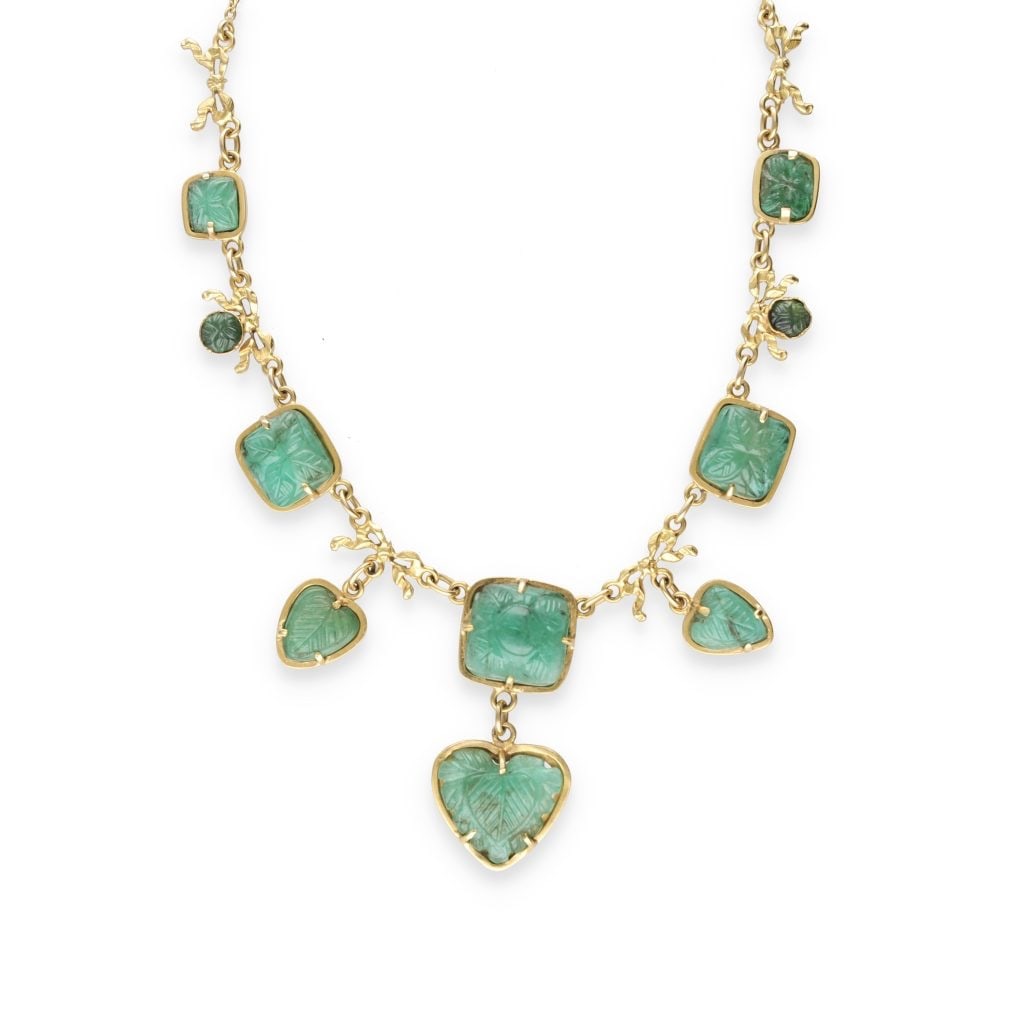 NECKLACE 1900 IN ENGRAVED EMERALDS AND YELLOW GOLD: NECKLACE 1900 IN ENGRAVED EMERALDS AND YELLOW GOLD Description: Refined drapery necklace composed of finely engraved emeralds, mounted on a 18k gold chain. Each stone has delicate carved patterns, bri