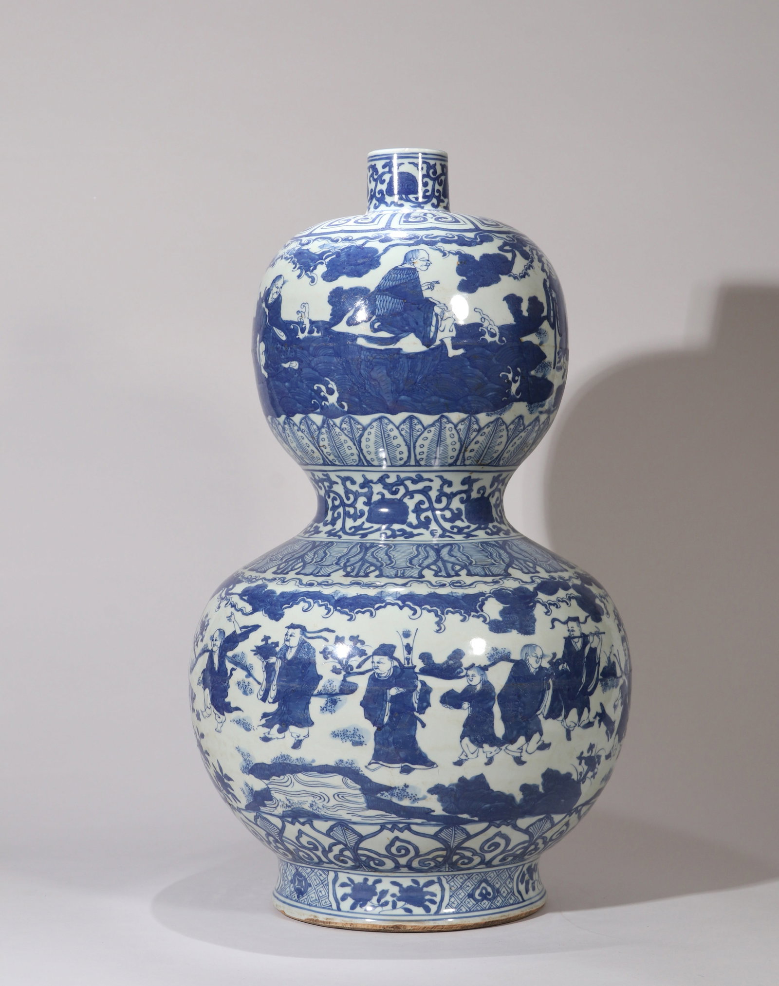 A BLUE-AND-WHITE 'IMMORTALS CELEBRATING SHOU' GOURD SHAPED VASE: A BLUE-AND-WHITE 'IMMORTALS CELEBRATING SHOU' GOURD SHAPED VASE Dimensions: Height: 56 cm (22.05 in.). All measurements are approximate.